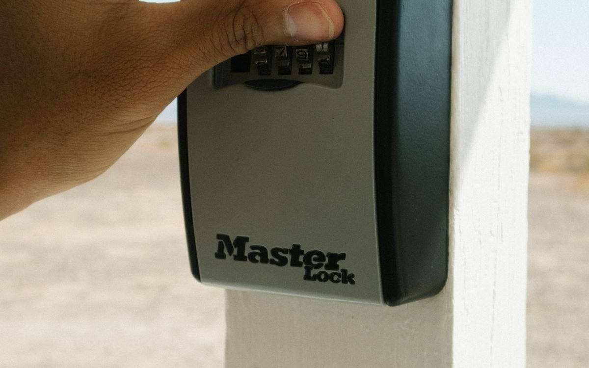 Main composant le code sur les quatre molettes d'une boîte à clés Master Lock