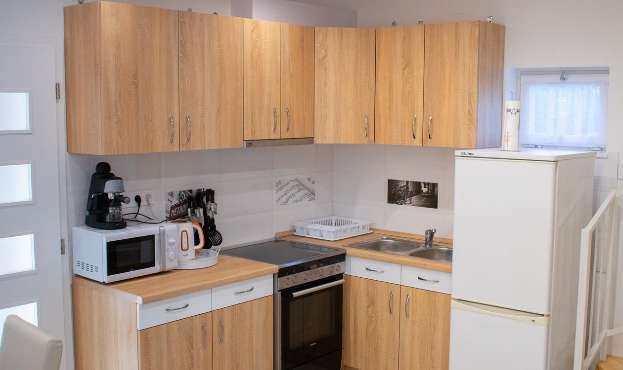 Cuisine équipée d'un logement meublé avec plaques de cuisson, four et réfrigérateur conformes au décret 2015-981