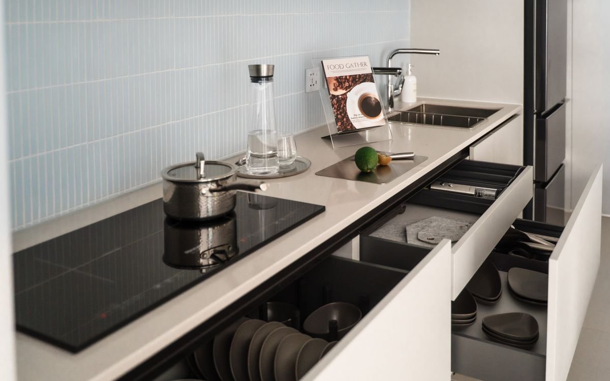 Tiroir de cuisine ouvert sous une plaque de cuisson à induction dans un logement équipé