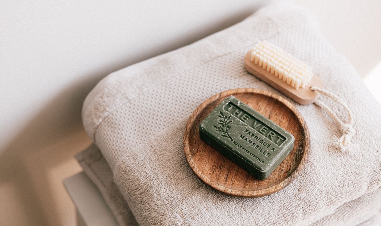 Savon naturel posé sur une pile de serviettes propres pliées, équipements de base d'une salle de bain Airbnb