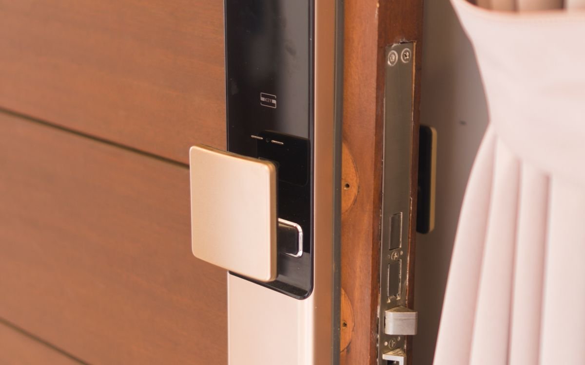 Serrure connectée à clavier installée sur une porte d'entrée en bois