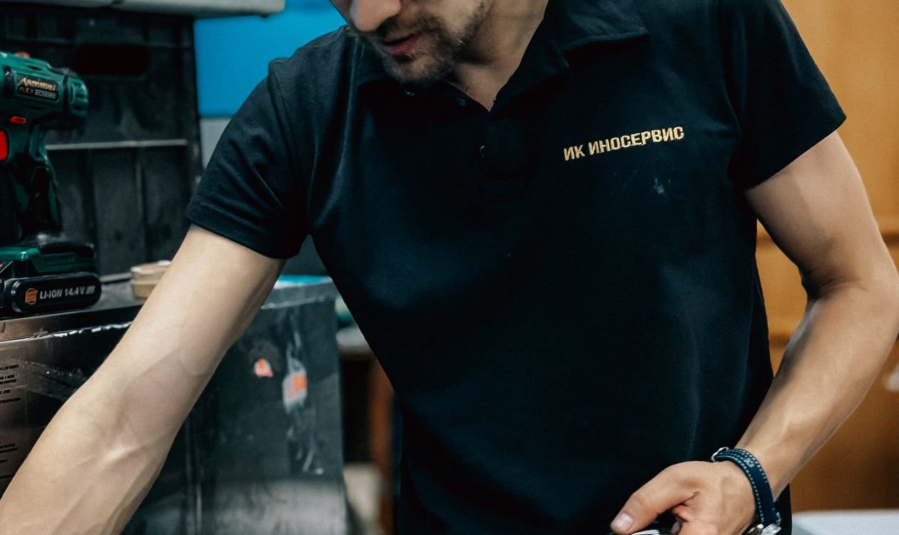 Technicien électroménager inspectant la carte électronique défaillante d'une plaque de cuisson à induction